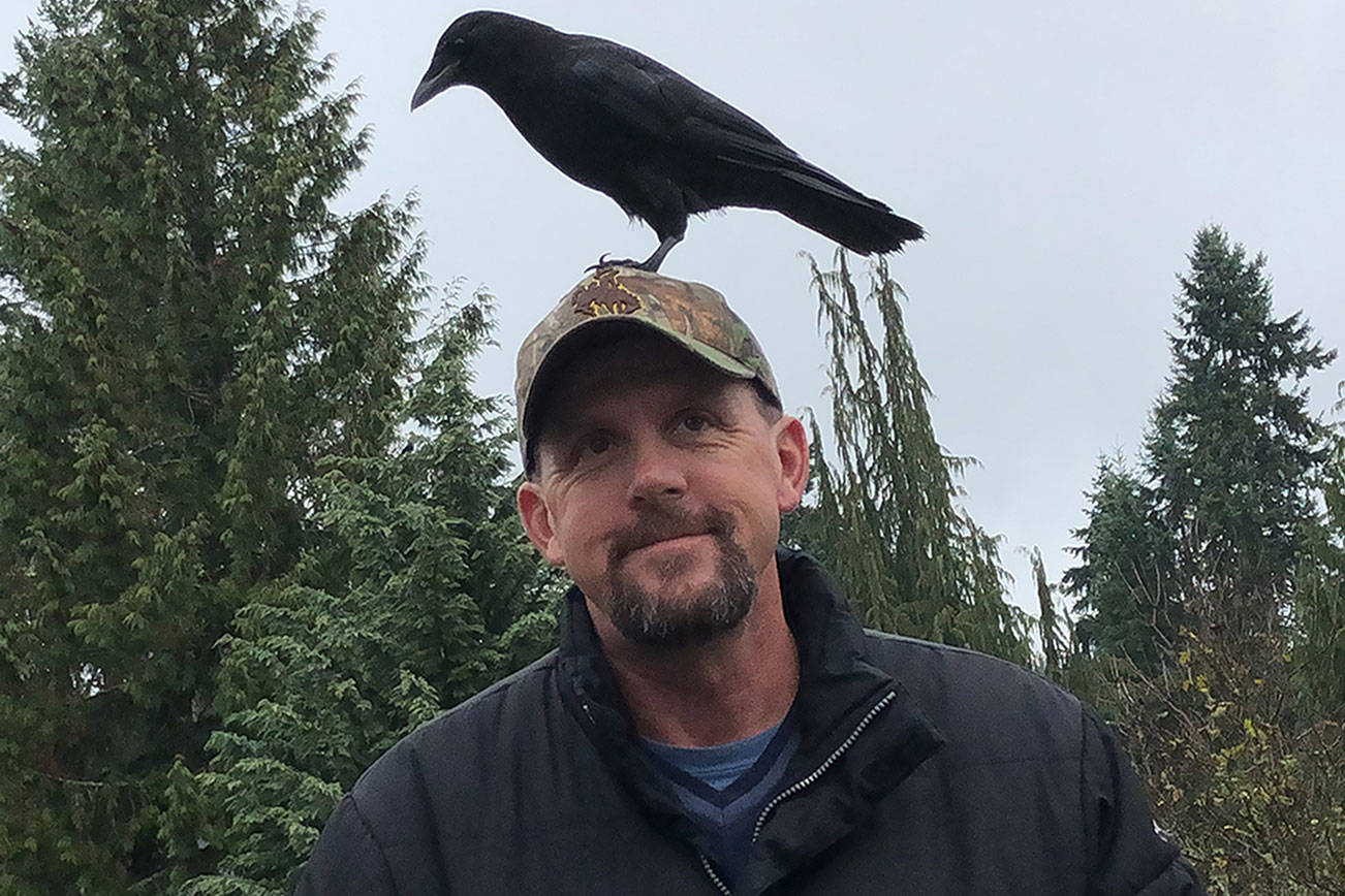 Renton resident Joe Copenhaver and his pet crow, T-Rex, share a moment Nov. 10. Photo by Andy Hobbs