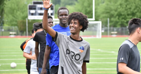 Mohamed Abdi gives a wave during training at Renton Memorial Stadium. Ben Ray / The Reporter