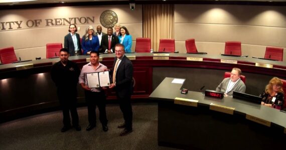 Business owner Isidro Rojas with the Renton City Council taking a photo with the Hispanic Heritage Month proclamation. (Screenshot from the Renton City Council meeting)