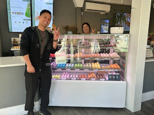 Picture of business owner Michael Huynh, employee Jemmy and a display of macarons. Photo by Janiyah Gibson/The Reporter