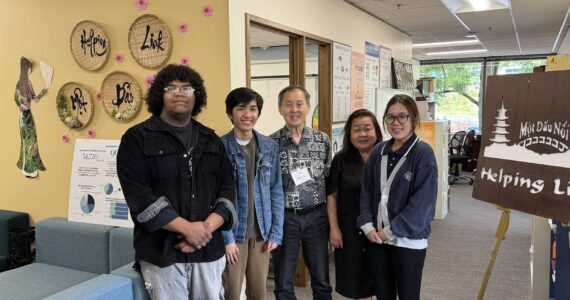 Executive Director Minh-Duc Nguyen (center right) and Ron Choi (center) rely on the work of volunteers to keep Helping Link running. Photo by Drew Dotson/Renton Reporter