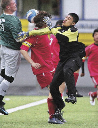 Renton goalie Luis Martinez tangles with teammate Brandon Schaefer and an Evergreen player in a play that was a close call but did not result in a goal in Renton’s 5-0 loss at Highline Memorial Stadium on Tuesday.