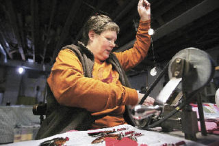 Kris Hill does the final assembly of a No. 1-5 Jack Lloyd All Diamond Troll Wednesday at her parents’ home in Renton. Hill’s parents bought the fishing tackle company in 1976 and have run it from their home ever since. Some of the tools they use date back to the company’s founding in 1916.