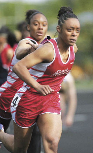 Renton’s Kanisha Calcote takes the baton from Mary Powell for the anchor leg of Renton’s 4x100 relay.